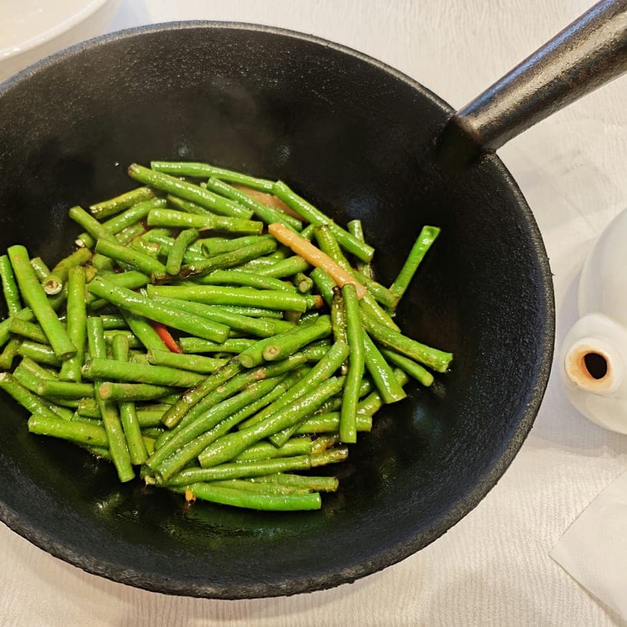 Blistered green beans with chilli in a cast iron pan.